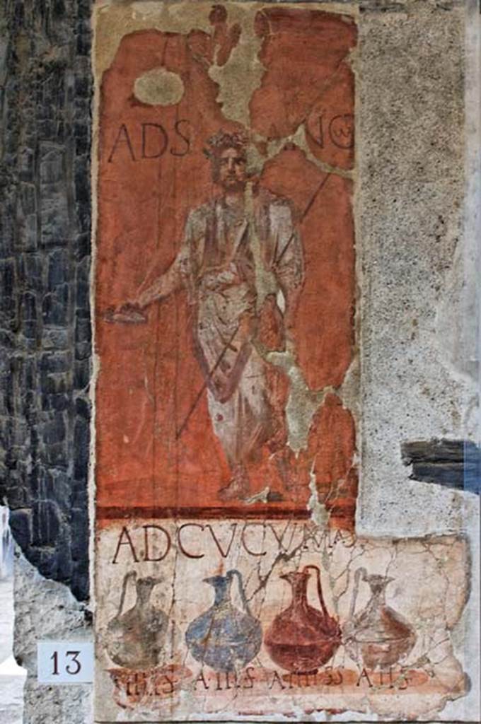 VI.13/14 Herculaneum, April 2010. Painted sign on pilaster between house entrance and shop. Looking south. Photo courtesy of Nicolas Monteix.
According to Cooley,
“the words ad Sancum appear painted next to an image of a bearded togate figure holding a libation dish and a staff, with his head garlanded. This figure has been interpreted as being the god Semo Sancus, associated with guaranteeing oaths.”
See Cooley, A. and M.G.L., 2014. Pompeii and Herculaneum: A Sourcebook. London: Routledge, (p.266-7, H80, (AE (1989)182c).